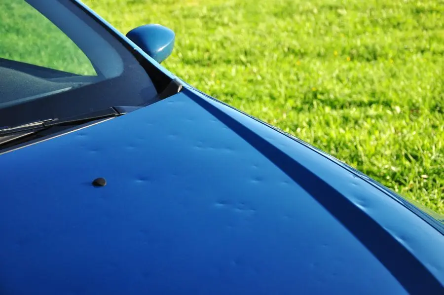 Carolina Collision and Frame Service | Blue car with hail damage on its hood